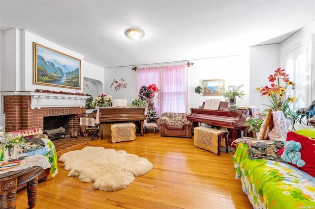 sitting room featuring plenty of natural light, light hardwood / wood-style floors, and a brick fireplace