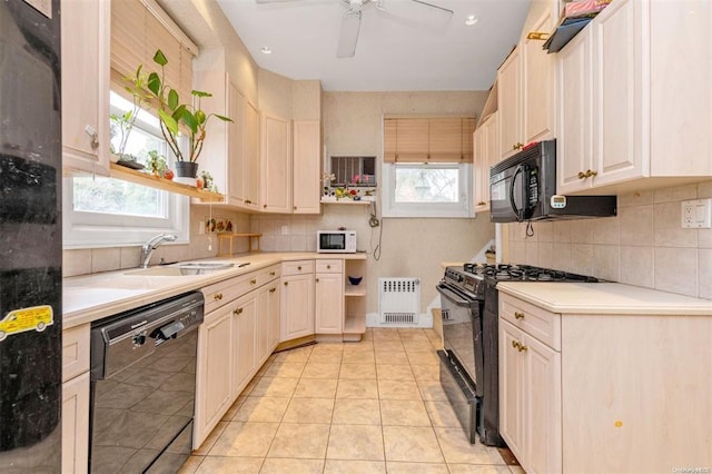 kitchen with black appliances, a healthy amount of sunlight, light tile patterned floors, and sink