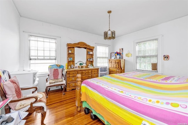 bedroom with wood-type flooring and multiple windows