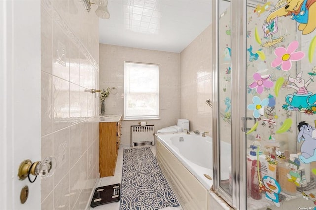 full bathroom with vanity, tile patterned floors, toilet, tile walls, and radiator heating unit