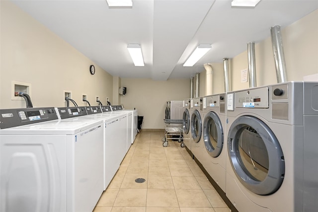 laundry area featuring washing machine and clothes dryer and light tile patterned floors