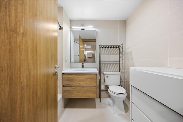 bathroom with tile patterned flooring, vanity, toilet, and tile walls