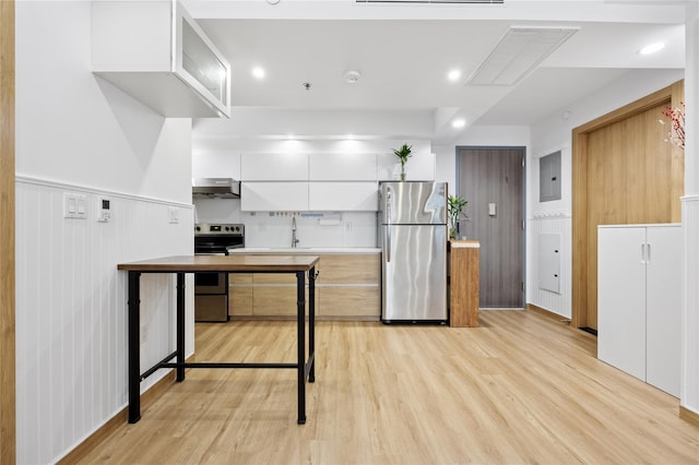 kitchen featuring stainless steel appliances, exhaust hood, light hardwood / wood-style flooring, electric panel, and white cabinetry