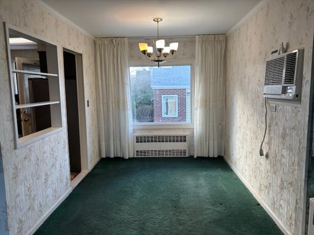 carpeted empty room featuring radiator heating unit, ornamental molding, and an inviting chandelier