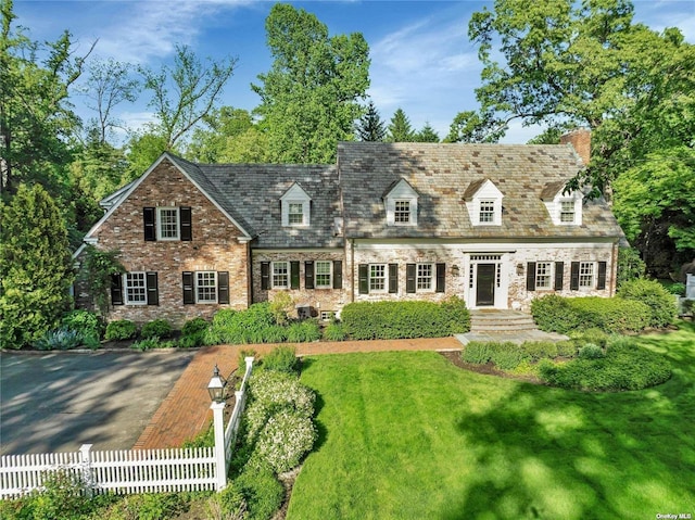 new england style home with a front lawn