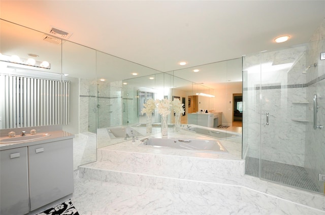 bathroom with vanity and shower with separate bathtub