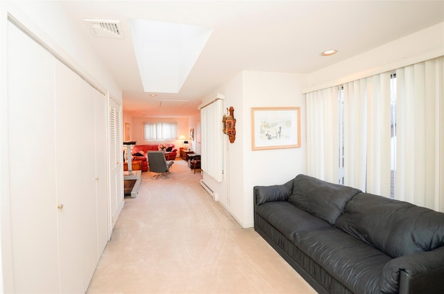 hallway with light colored carpet and baseboard heating