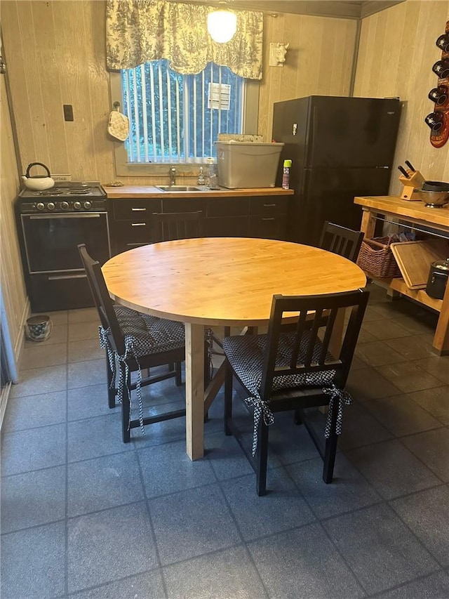 dining area featuring sink and wood walls