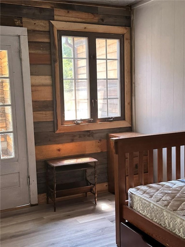 bedroom featuring wood walls and light hardwood / wood-style flooring