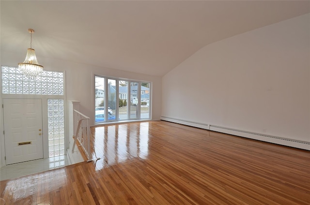 entrance foyer with light wood-type flooring, vaulted ceiling, a baseboard radiator, and a notable chandelier