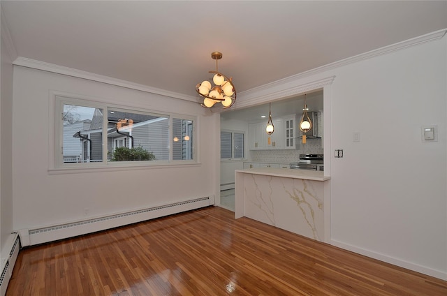 unfurnished dining area featuring baseboard heating, crown molding, and hardwood / wood-style floors