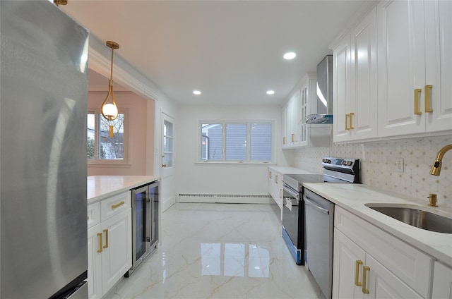 kitchen featuring decorative light fixtures, white cabinetry, stainless steel appliances, sink, and light stone counters