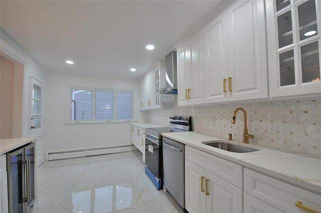 kitchen with a baseboard heating unit, stainless steel appliances, wall chimney exhaust hood, white cabinets, and sink