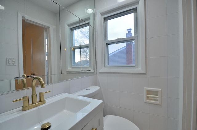 bathroom featuring toilet, tile walls, backsplash, and vanity