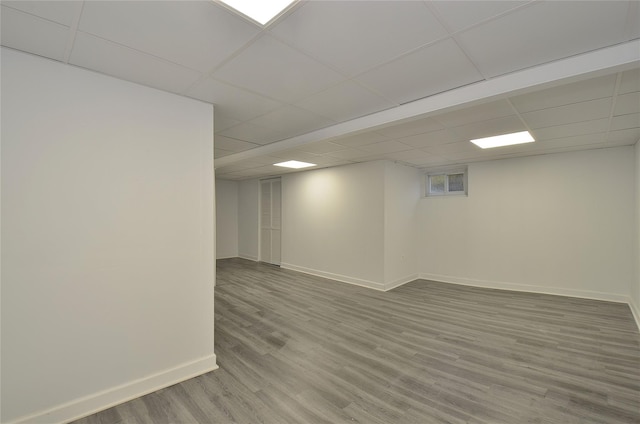 basement with wood-type flooring and a drop ceiling