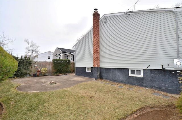 view of property exterior with a lawn and a patio