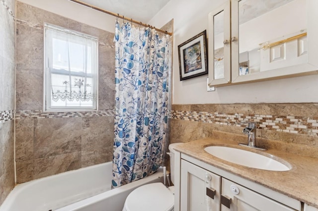 full bathroom with shower / tub combo with curtain, vanity, toilet, and tile walls