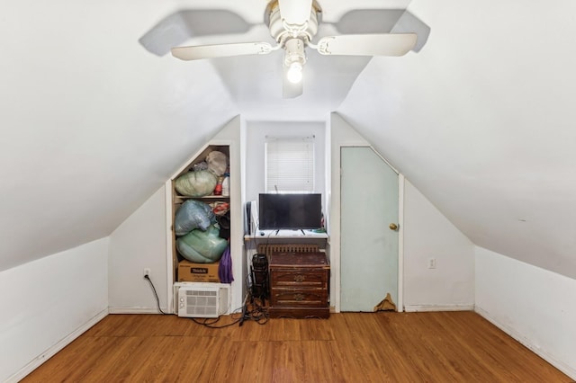 additional living space featuring hardwood / wood-style flooring, vaulted ceiling, an AC wall unit, and ceiling fan