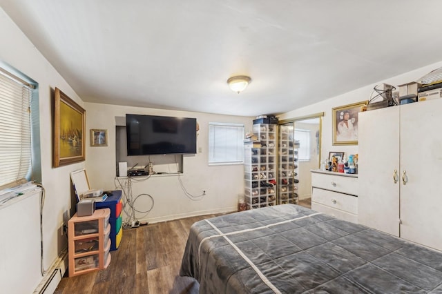 bedroom featuring a baseboard heating unit and dark hardwood / wood-style flooring