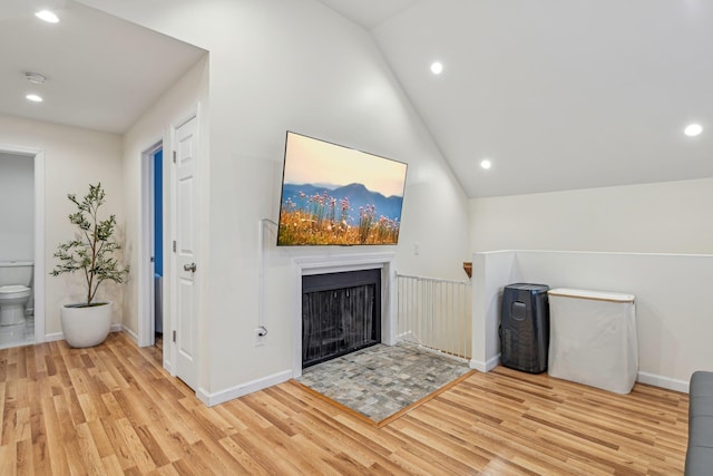 unfurnished living room featuring vaulted ceiling and light hardwood / wood-style flooring