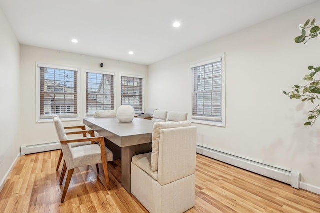 dining space featuring a baseboard radiator and light wood-type flooring