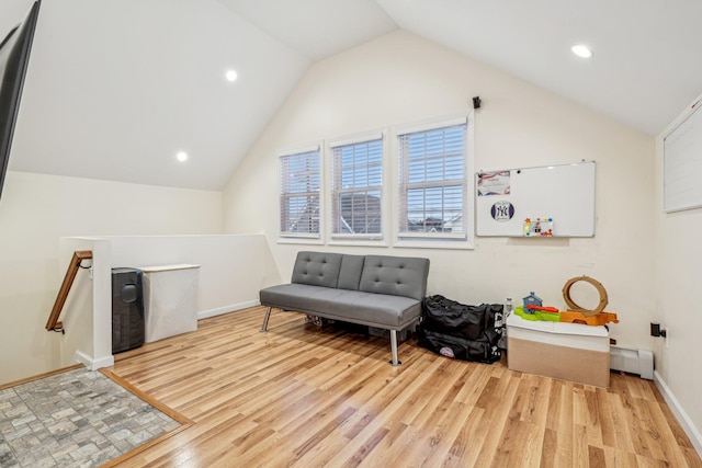 living area with lofted ceiling, a baseboard heating unit, and light hardwood / wood-style flooring