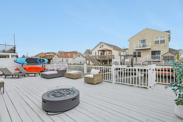 wooden deck with an outdoor living space with a fire pit