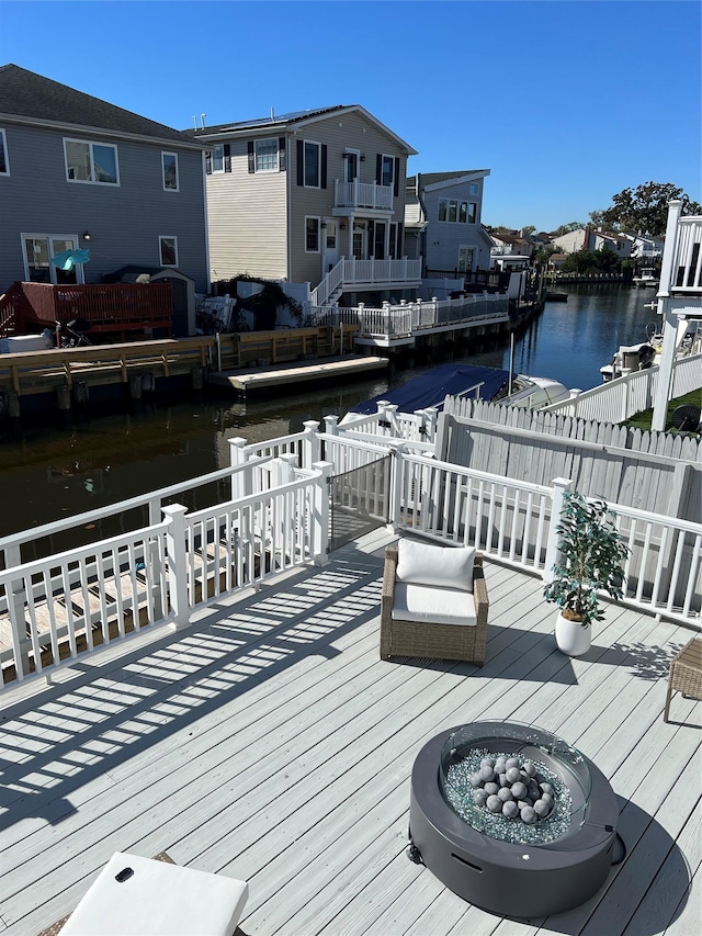 dock area with a deck with water view and an outdoor fire pit