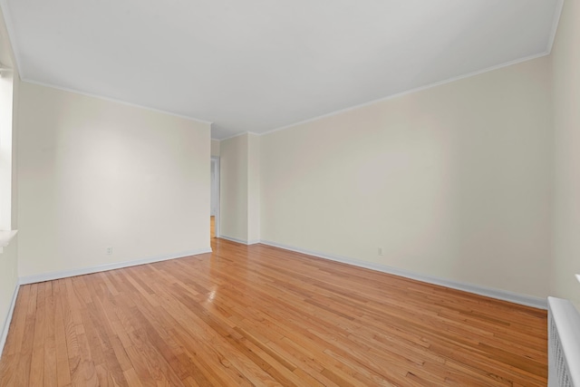 spare room with ornamental molding and light hardwood / wood-style flooring