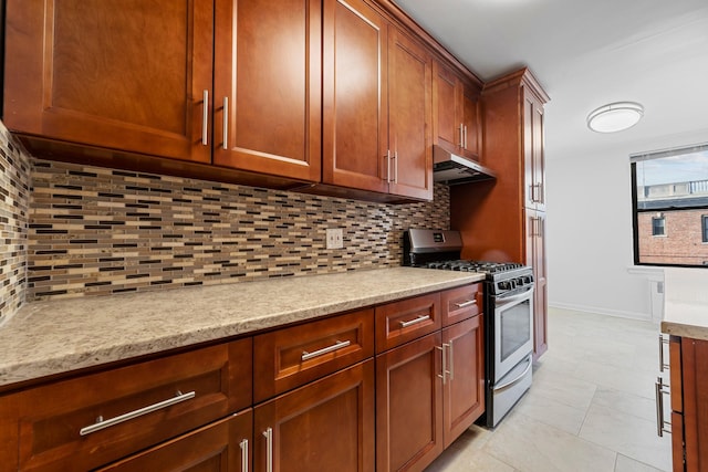 kitchen featuring decorative backsplash, gas range, light tile patterned floors, and light stone counters