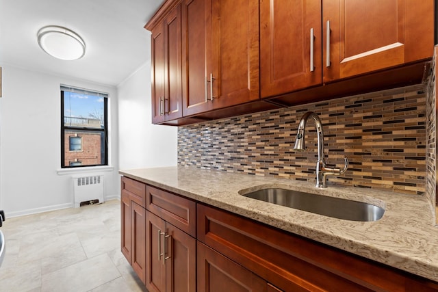 kitchen with light stone countertops, backsplash, sink, light tile patterned floors, and radiator heating unit