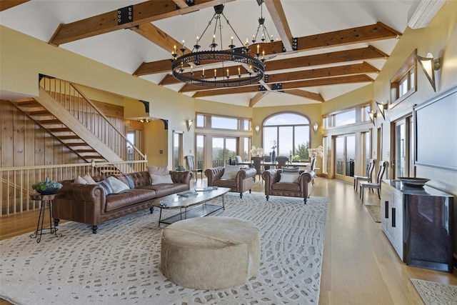 living room with beamed ceiling, a notable chandelier, high vaulted ceiling, and light hardwood / wood-style flooring