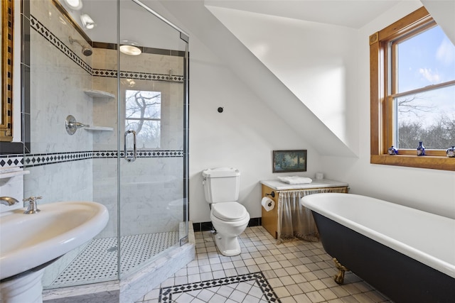 full bathroom with tile patterned flooring, shower with separate bathtub, vaulted ceiling, and toilet