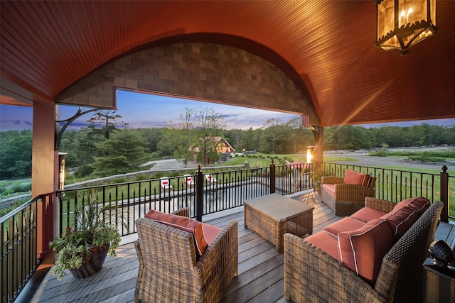 deck at dusk featuring an outdoor hangout area