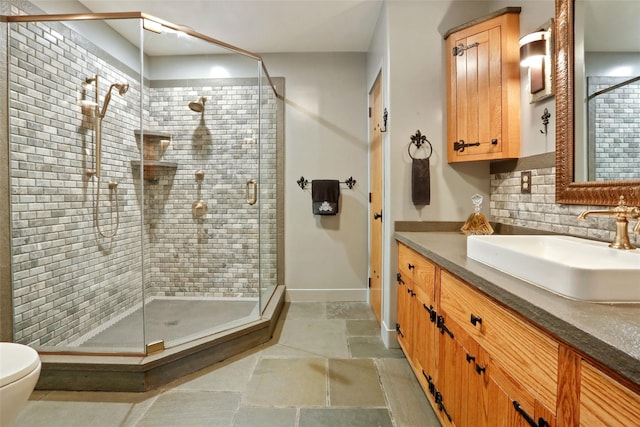 bathroom with a shower with door, vanity, backsplash, and toilet