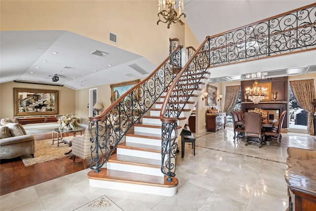 stairway with a high ceiling, a notable chandelier, and tile patterned floors