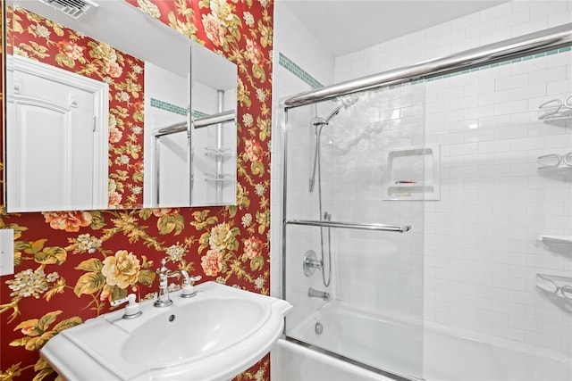 bathroom with enclosed tub / shower combo and sink