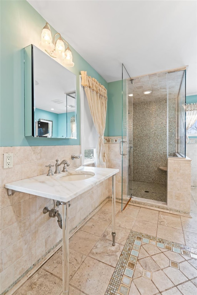 bathroom featuring tiled shower and tile walls