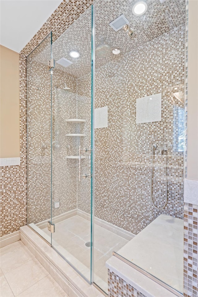 bathroom featuring tile patterned flooring, tile walls, and a shower with shower door