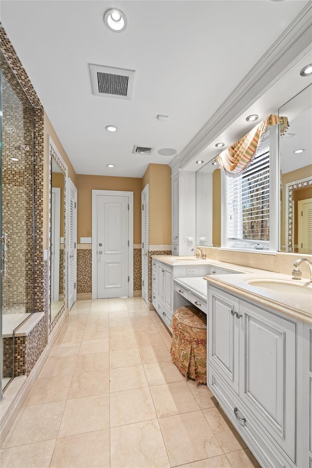 bathroom with a shower with door, vanity, and tile patterned floors