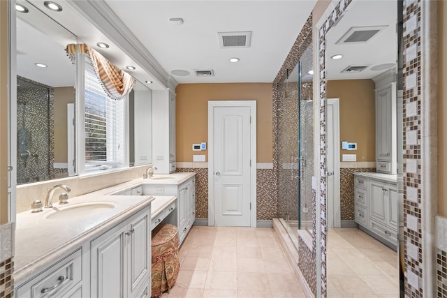 bathroom featuring tile patterned flooring, vanity, a shower with door, and tile walls