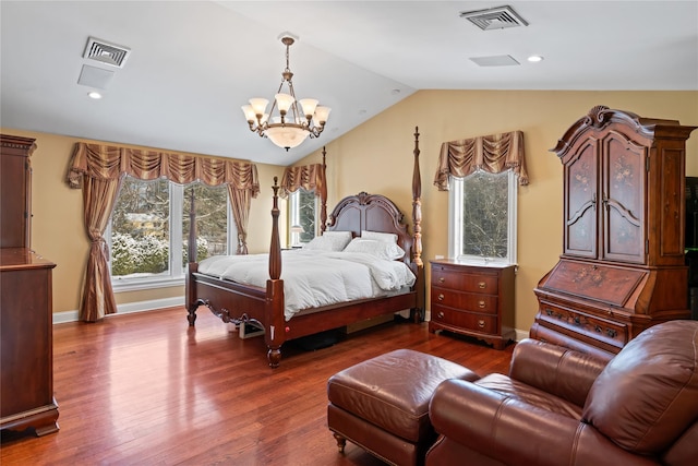 bedroom with vaulted ceiling, a chandelier, and hardwood / wood-style floors