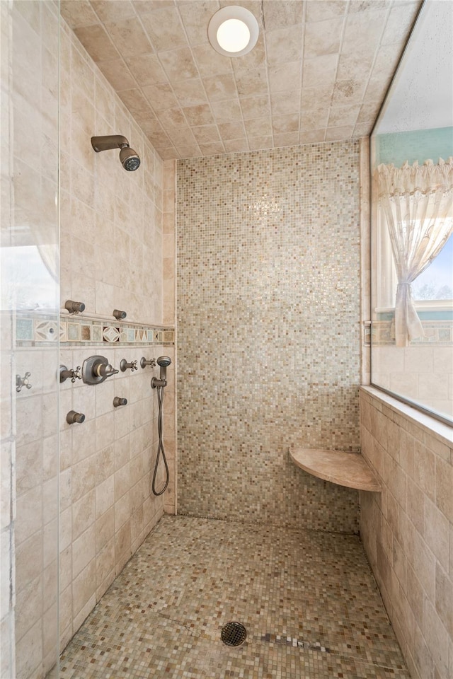 bathroom featuring tiled shower and tile walls