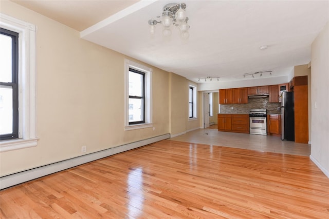 unfurnished living room with track lighting, light hardwood / wood-style flooring, and baseboard heating