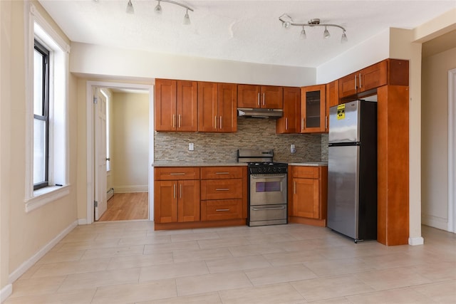 kitchen featuring decorative backsplash, plenty of natural light, light tile patterned flooring, and stainless steel appliances