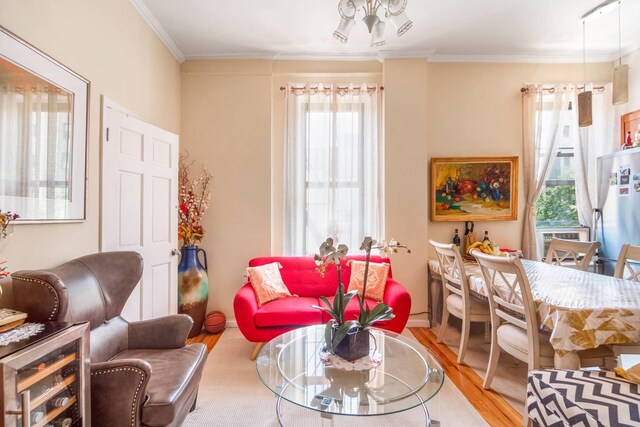 sitting room with wine cooler, light hardwood / wood-style flooring, and ornamental molding