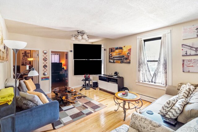 living room with light wood-type flooring, a textured ceiling, and a notable chandelier