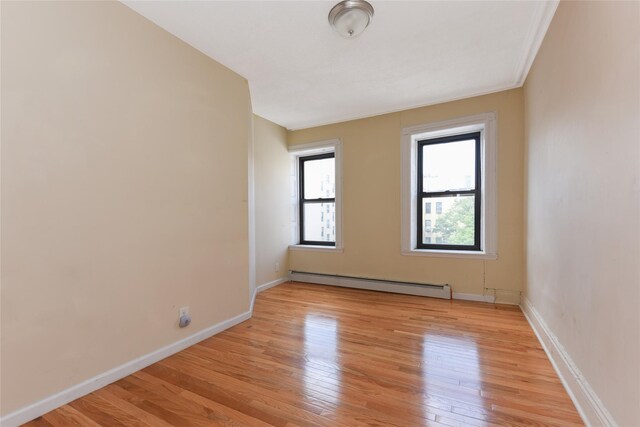 unfurnished room featuring light hardwood / wood-style flooring and a baseboard radiator