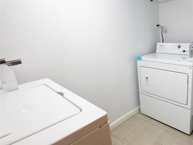 washroom featuring washer and clothes dryer and light tile patterned flooring