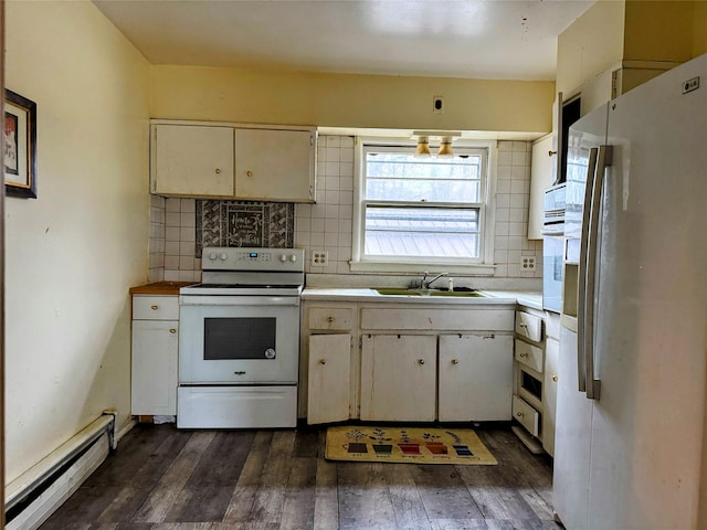 kitchen with backsplash, white appliances, baseboard heating, sink, and dark hardwood / wood-style floors